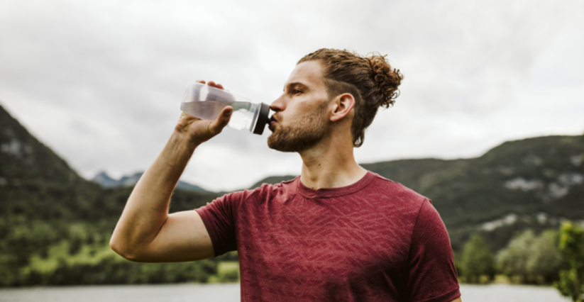 man drinking water after running